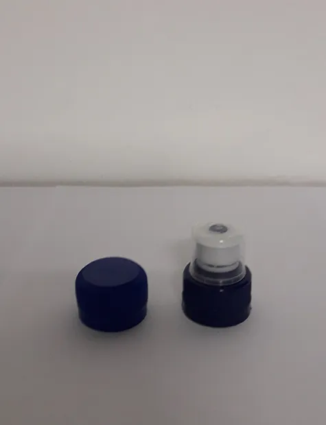 Two blue bottle caps, one flat and one sports cap